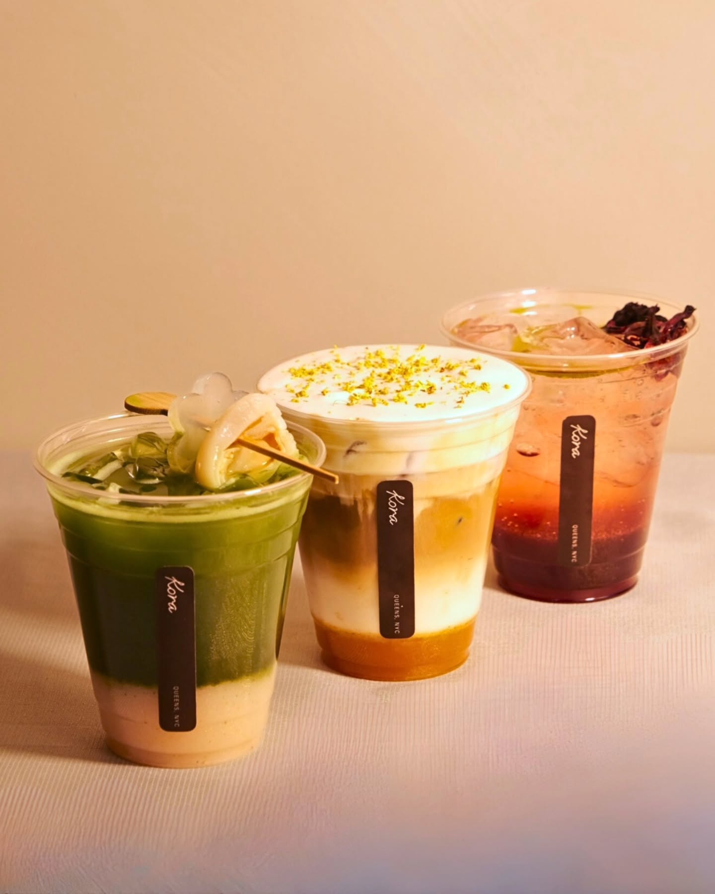 Three iced Kora drinks lined up on a counter